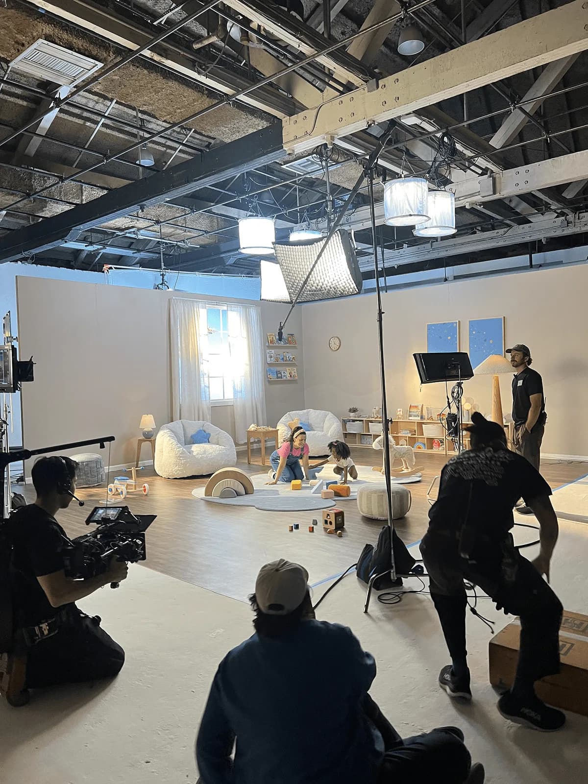 Film crew shooting Ms. Rachel and a toddler on the Millie Moon playroom set