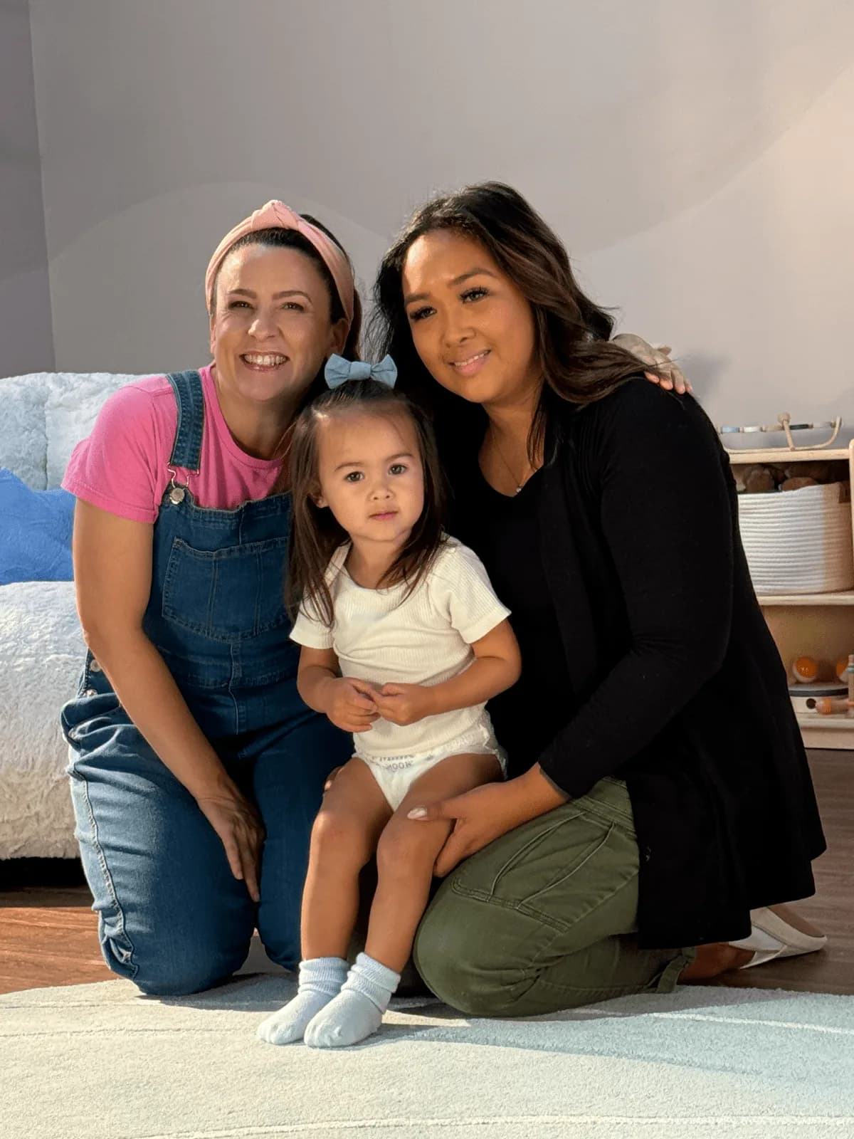Ms. Rachel kneeling with a toddler and their parent on the Millie Moon playroom set