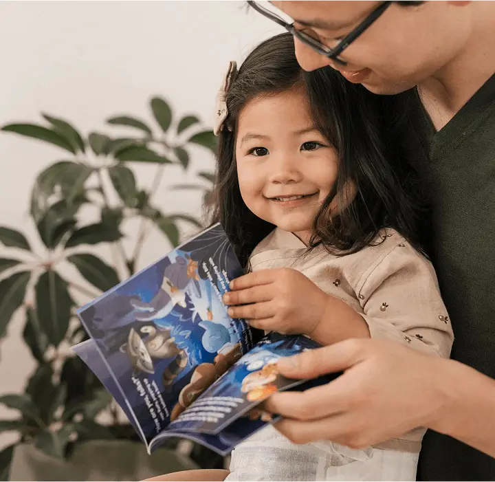Parent and smiling toddler reading a Millie Moon storybook together